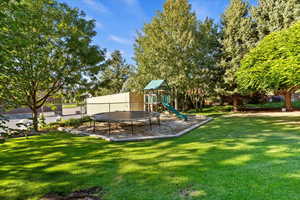 View of yard featuring a trampoline, a playground, and a patio