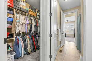 Hallway featuring light colored carpet and light tile patterned flooring