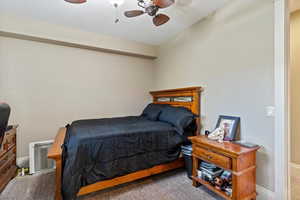 Bedroom with carpet, a textured ceiling, and a ceiling fan