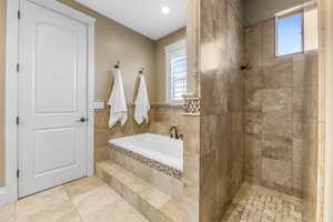Full bathroom featuring a bath and tiled shower