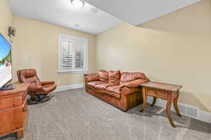 Living room with carpet floors and a textured ceiling