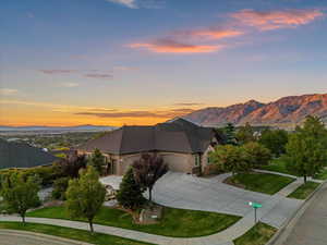 View of front facade featuring a garage, driveway, a yard, a mountain view, and brick siding