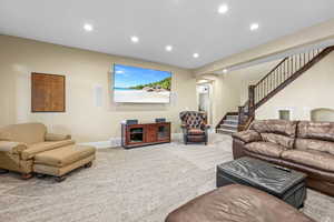 Carpeted living room featuring recessed lighting and stairs