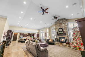 Living area featuring recessed lighting, crown molding, healthy amount of natural light, a stone fireplace, and ceiling fan