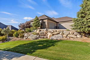 View of side of home with brick siding, a lawn, and an attached garage