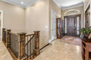 Entrance foyer featuring crown molding and light tile patterned floors