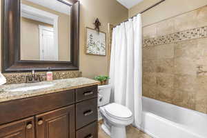Bathroom with shower / bath combination with curtain and vanity