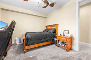 Carpeted bedroom featuring ceiling fan and baseboards