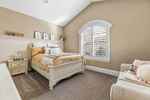 Bedroom featuring lofted ceiling and carpet flooring