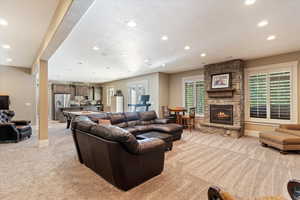 Living room featuring light colored carpet, recessed lighting, a fireplace, and a textured ceiling