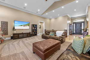 Living area with crown molding, recessed lighting, healthy amount of natural light, and high vaulted ceiling