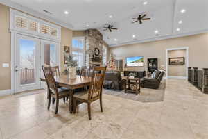 Dining space with a fireplace, a ceiling fan, crown molding, recessed lighting, and high vaulted ceiling