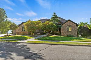 View of front of house featuring a front lawn and stone siding