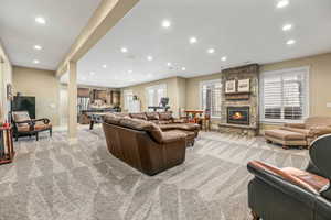 Living area with recessed lighting, light carpet, and a fireplace
