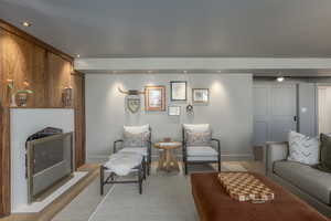 Living area with a fireplace, wood finished floors, and recessed lighting