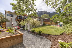 Rear view of property with a garden, a patio, stairway, a playground, and a deck with mountain view