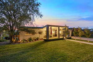 View of front of property featuring concrete driveway, a yard, covered porch, and a garage