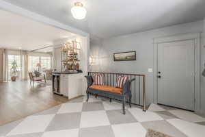 Foyer entrance with a dry bar, beverage cooler, recessed lighting, and light flooring