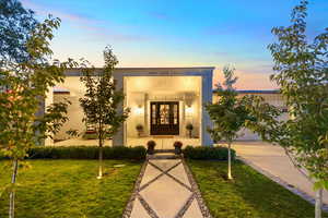 View of front of property featuring french doors, a front yard, and an attached garage