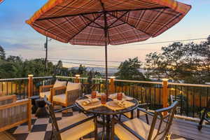 Wooden terrace featuring outdoor dining area and outdoor lounge area and valley views