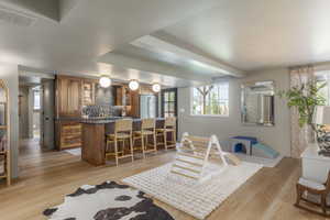 Dining area with beamed ceiling and light wood-style flooring