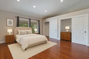 Bedroom with recessed lighting, vaulted ceiling, dark wood-type flooring, and multiple closets