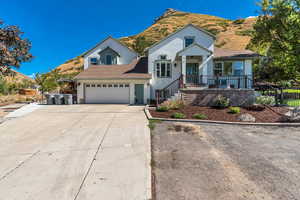 View of front of property featuring concrete driveway, a mountain view, a garage, covered porch, and roof with shingles