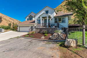 View of front of property with driveway, a garage, a mountain view, and roof with shingles