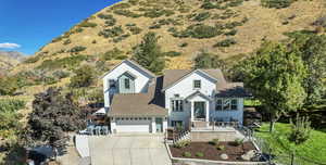 View of front of home with concrete driveway, a garage, and a shingled roof