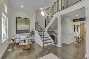 Living area featuring wood walls, wood finished floors, stairway, a barn door, and recessed lighting
