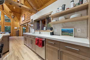 Kitchen featuring open shelves, light wood-style floors, rustic walls, a wood ceiling with exposed beams, and dishwasher