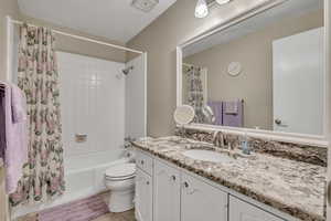 Full bathroom featuring shower / bath combination with curtain and vanity