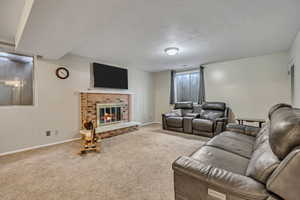 Carpeted living area with a textured ceiling and a fireplace