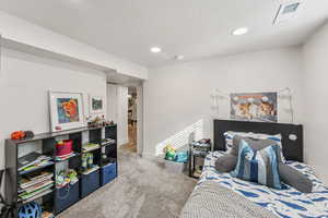 Carpeted bedroom featuring a textured ceiling and recessed lighting