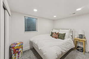 Carpeted bedroom with recessed lighting and baseboards
