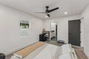 Carpeted bedroom featuring attic access, ceiling fan, recessed lighting, and ensuite bathroom
