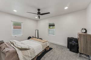 Carpeted bedroom featuring ceiling fan, recessed lighting, and a textured ceiling