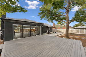 Wooden terrace with a fenced backyard and a patio area