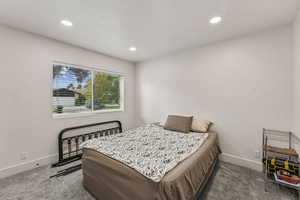 Carpeted bedroom featuring recessed lighting and a textured ceiling