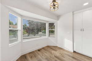Unfurnished dining area featuring light wood finished floors and recessed lighting