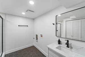 Washroom featuring hookup for a washing machine, dark tile patterned flooring, and recessed lighting
