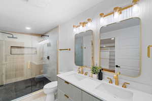 Full bath featuring a shower stall, double vanity, light tile patterned floors, and recessed lighting