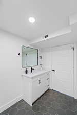 Bathroom with vanity and dark tile patterned floors