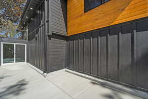 Property entrance with a patio area and board and batten siding
