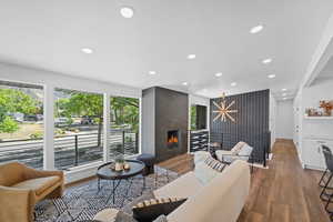 Living area with wood finished floors, recessed lighting, a high end fireplace, and a textured ceiling