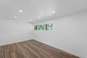 Empty room with recessed lighting, wood finished floors, and a textured ceiling
