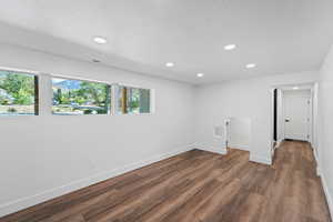 Unfurnished room with recessed lighting, dark wood finished floors, and a textured ceiling