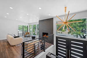Stairway featuring a fireplace, wood finished floors, recessed lighting, and a textured ceiling
