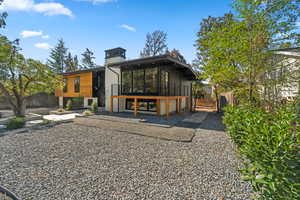 Rear view of house with a chimney and a balcony
