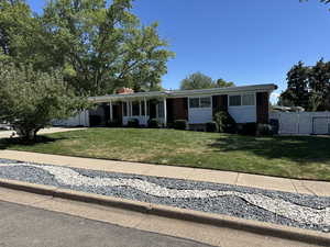 Ranch-style home featuring a chimney, an attached garage, and driveway